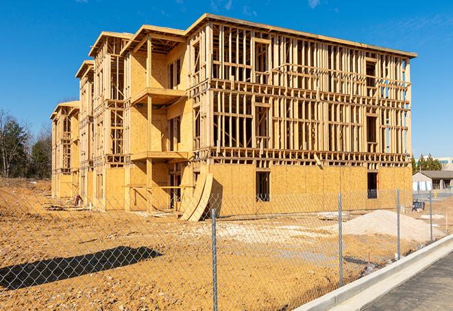 a temporary chain link fence in front of a building under construction, ensuring public safety in Bartlesville, OK